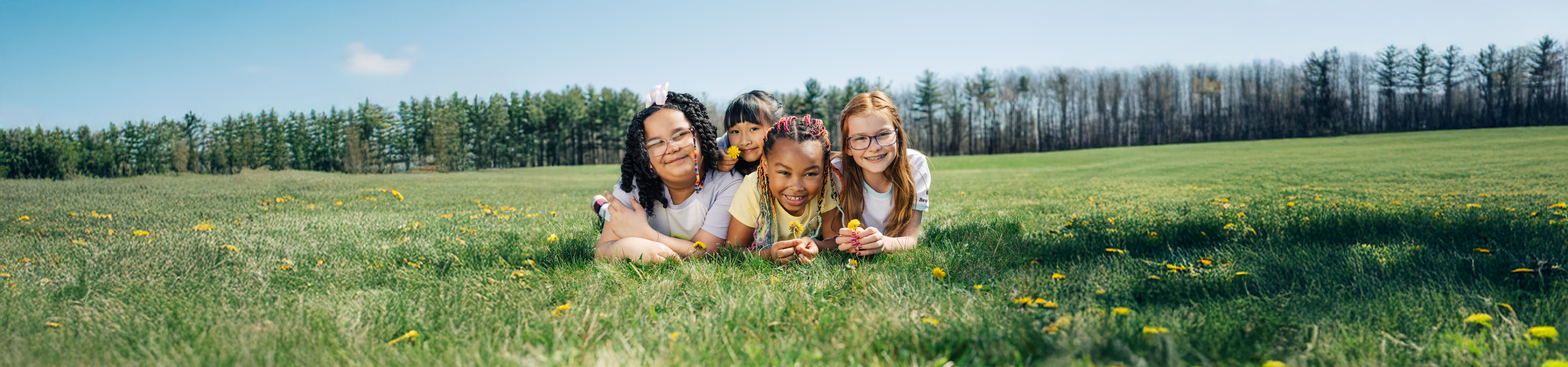  two Junior Girl Scouts sitting on a boulder 