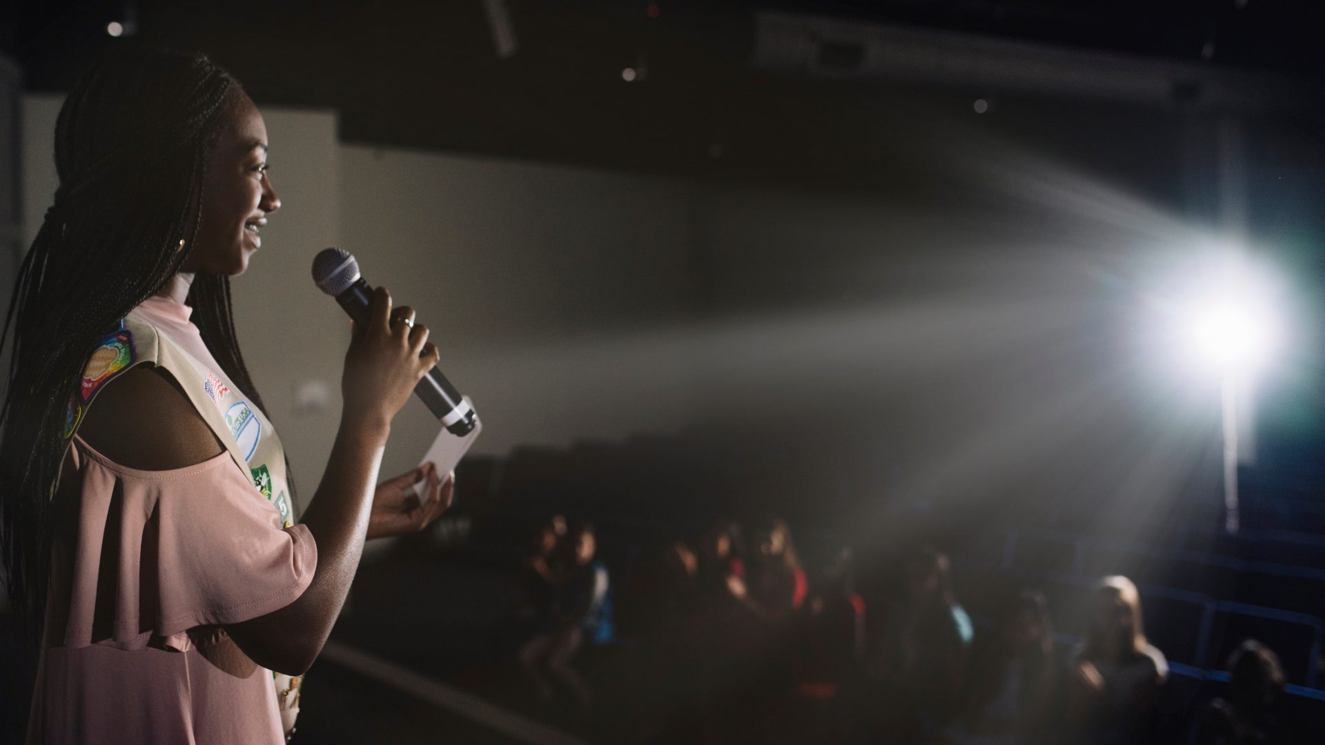 young teen girl speaking in front of an audience 