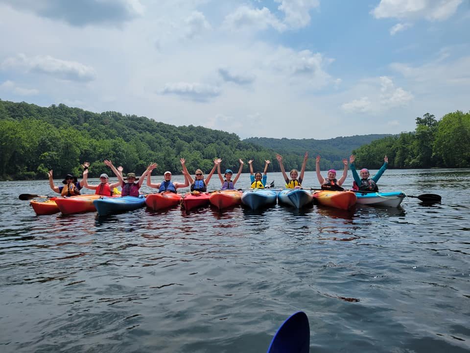 girls cheering along the lake in their kayak's 