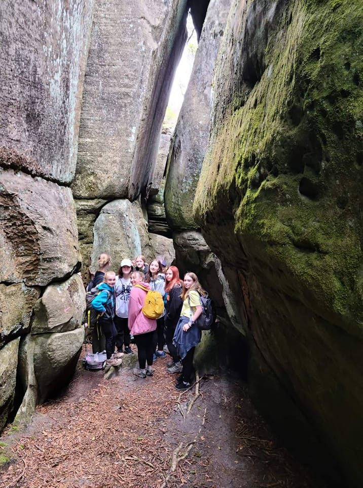 adventurer girls posing in front of large rock formation