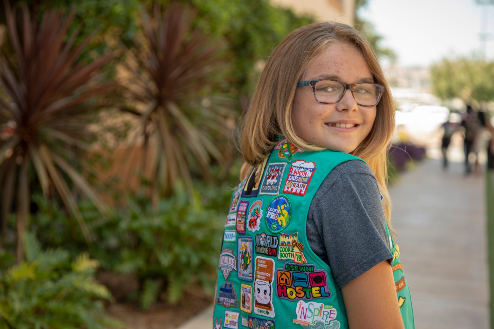 Junior girl wearing uniform. Her back turned away so you can see her badges. 